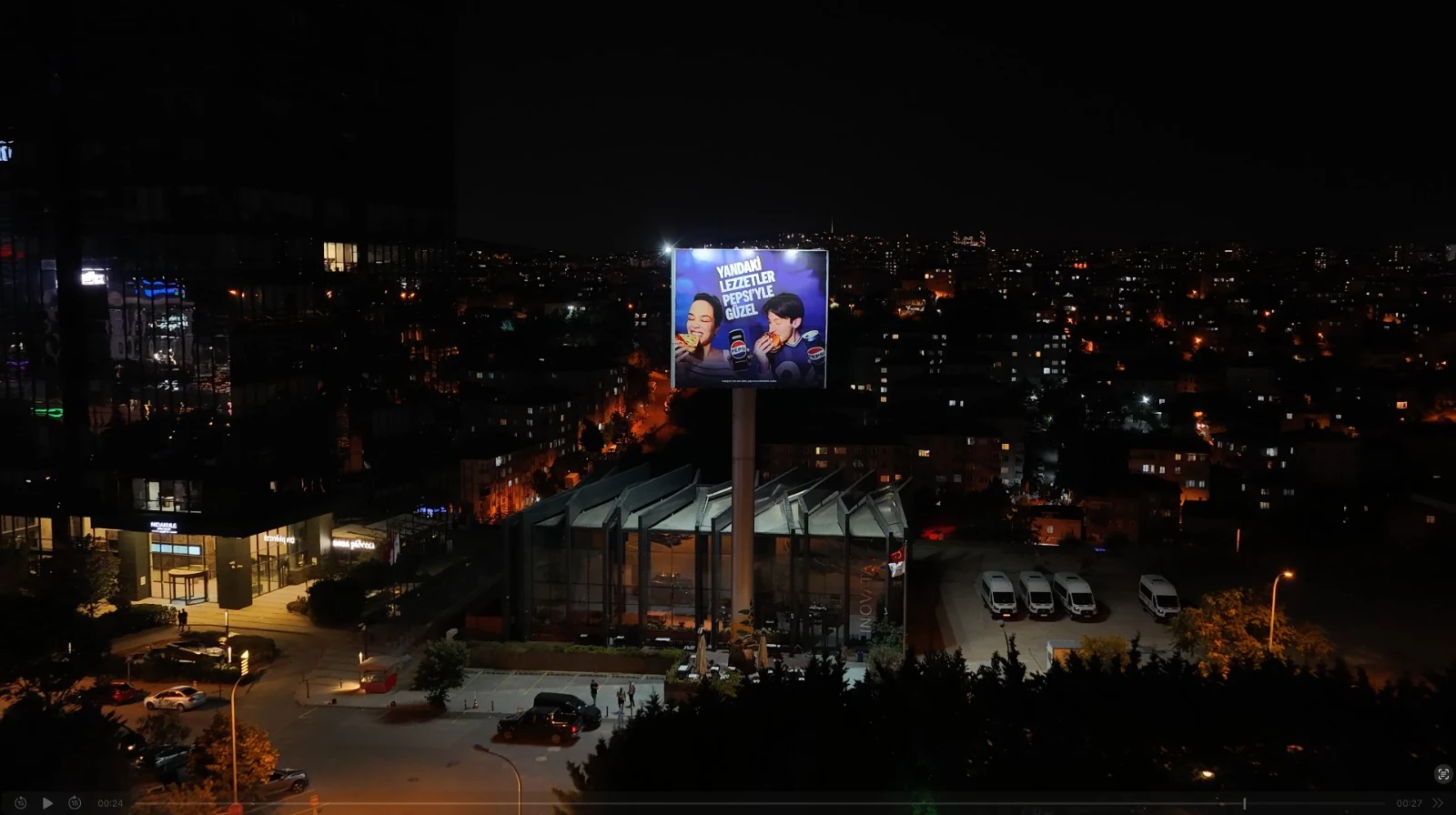 An illuminated elevated advertising billboard among city lights in Istanbul
